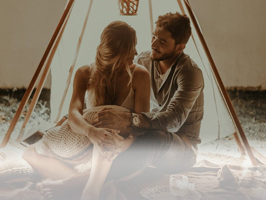 Couple looking into each others eyes while cuddling on romantic getaway.