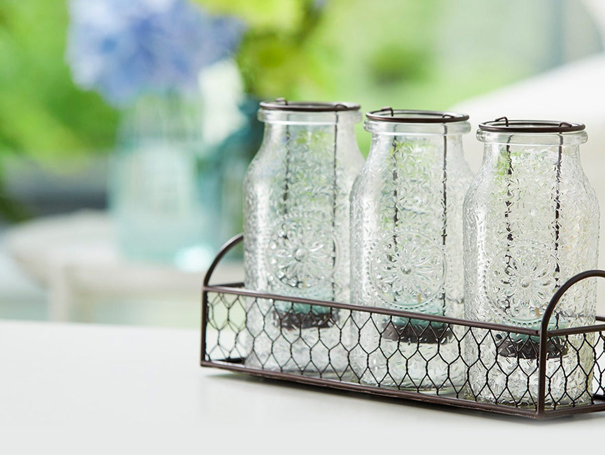 A group of three Vintage Milk Bottle Lantern Candle Holders in a basket.