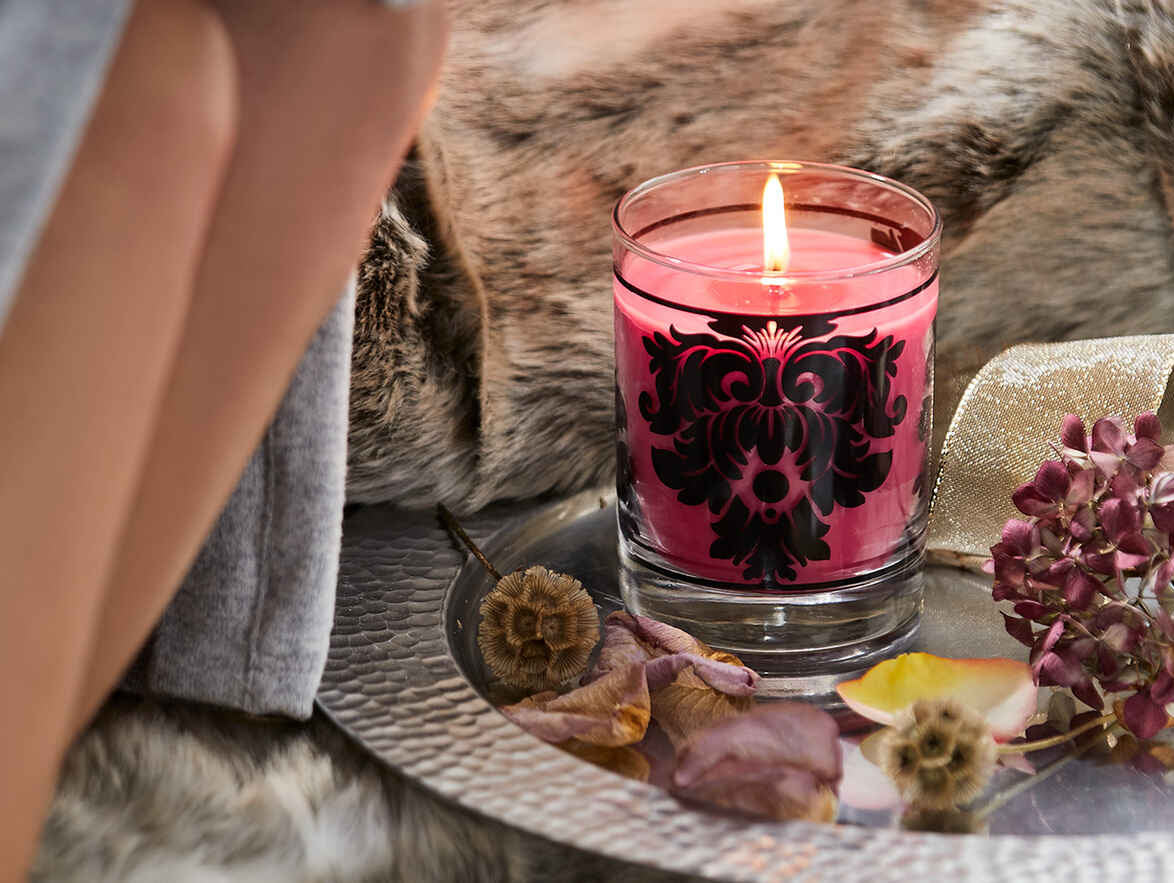 Candle Jar burning on a silver platter.
