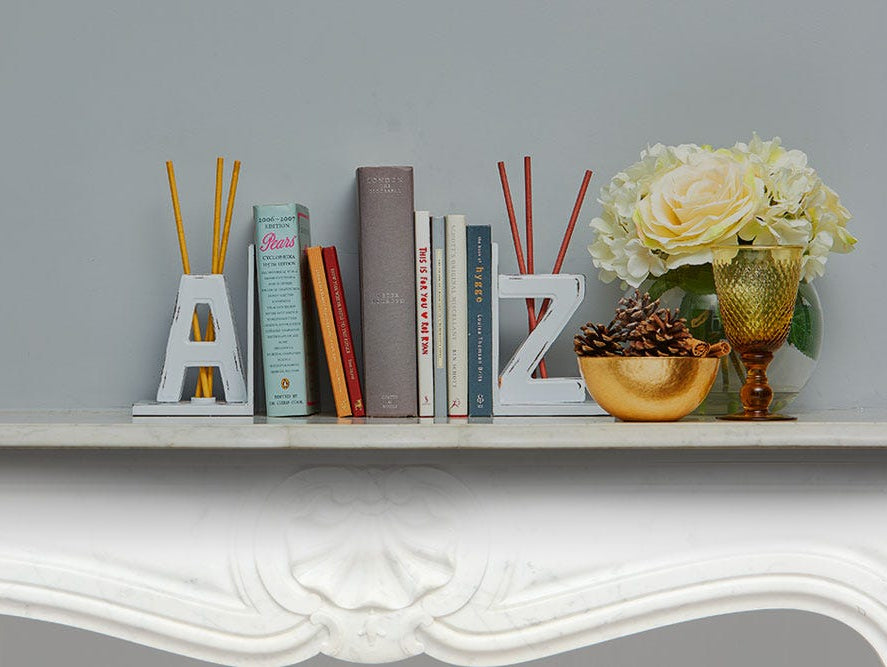 Books on a shelf between A and Z bookend fragrance stick holders with SmartScents Fragrance Sticks.