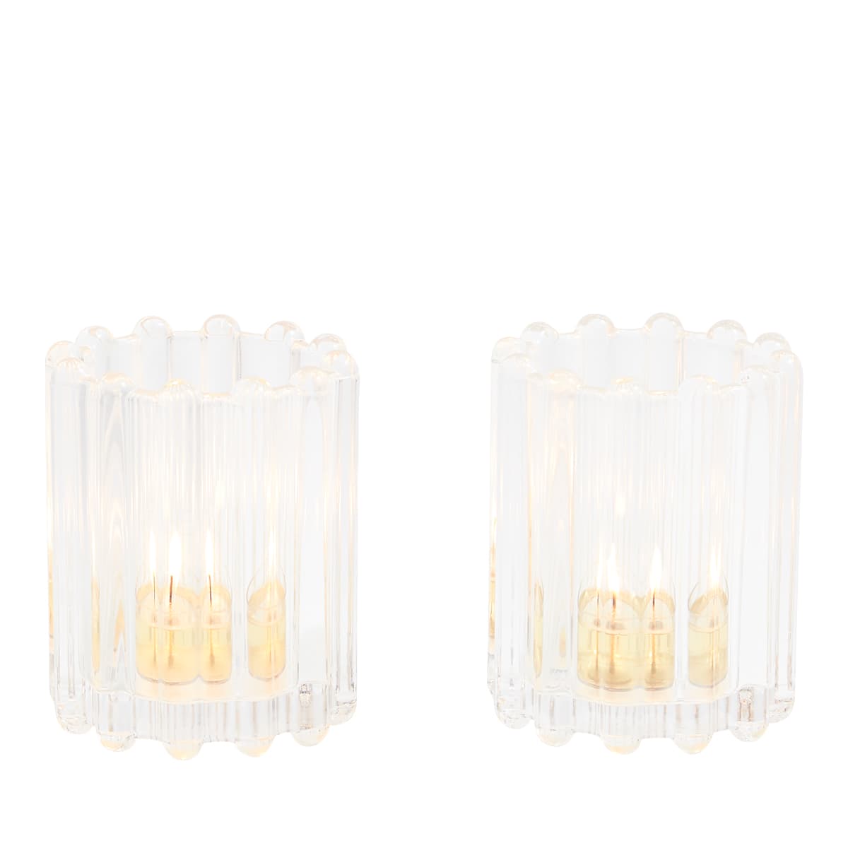 A pair of Ripple Glass Tealight/Votive Holder Pair, clear glass with lit tealights against a white background.