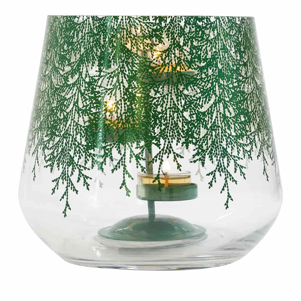 A clear glass hurricane with a metallic finish, adorned with a lace-like pattern of evergreen branches. It includes a metal tealight holder shown with a lit tealights.