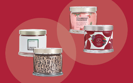 Four candles with different designs on a red background