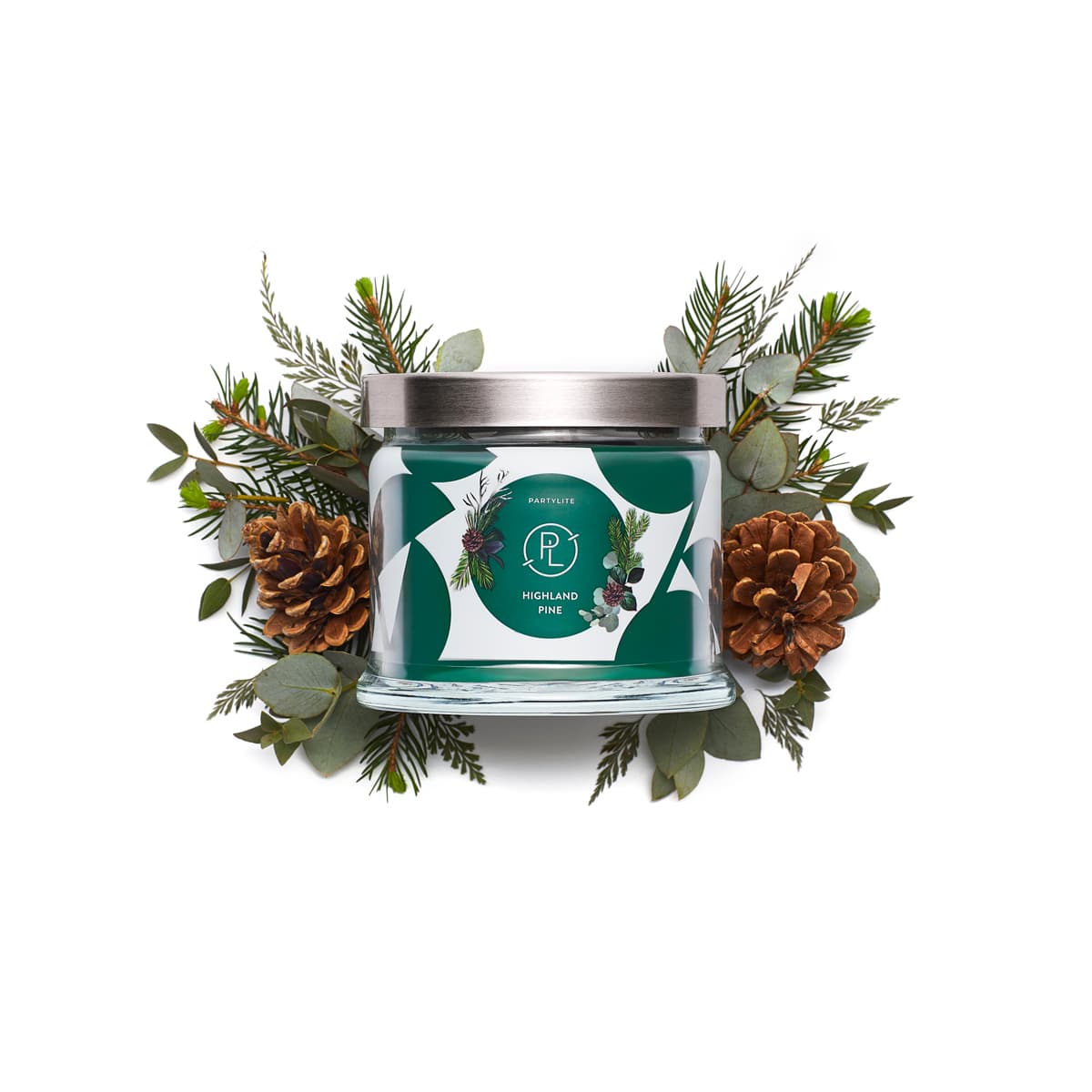 Highland Pine 3-wick Jar Candle surrounded by Pine cones and leaves against a white background.
