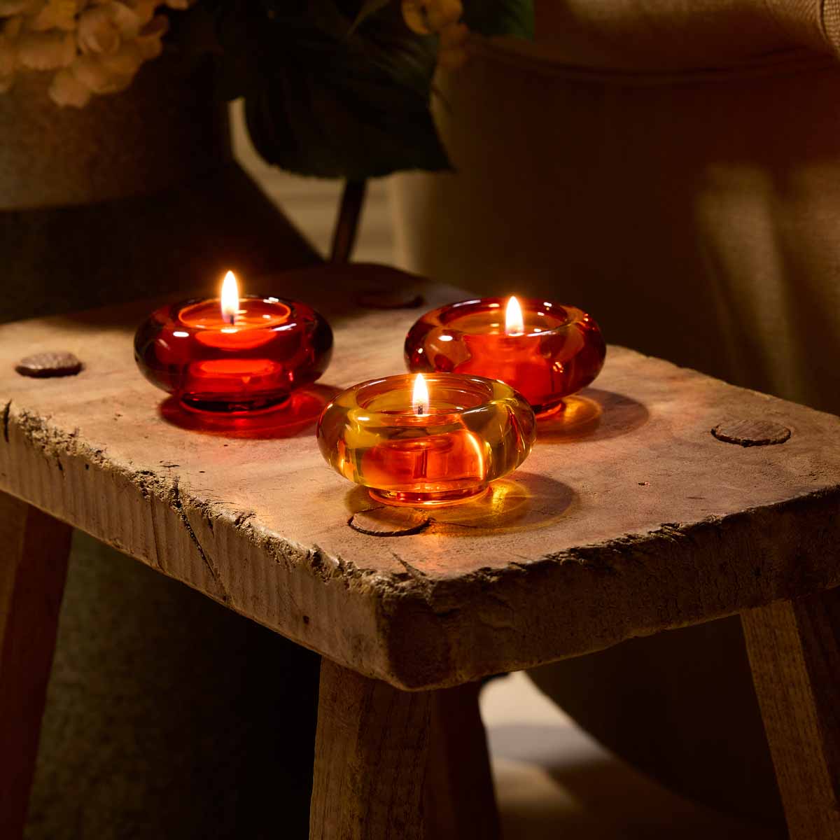Golden Honey Tealight Holder Trio with lit tealights on a wooden table.