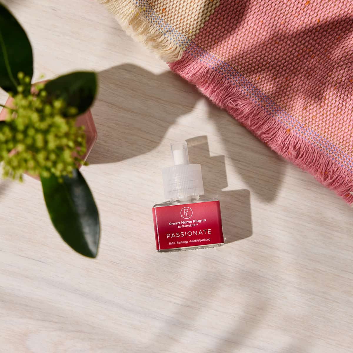 Passionate Refill for the Smart Home Plug in shown on a light grained surface with a plant and a woven cloth next to it