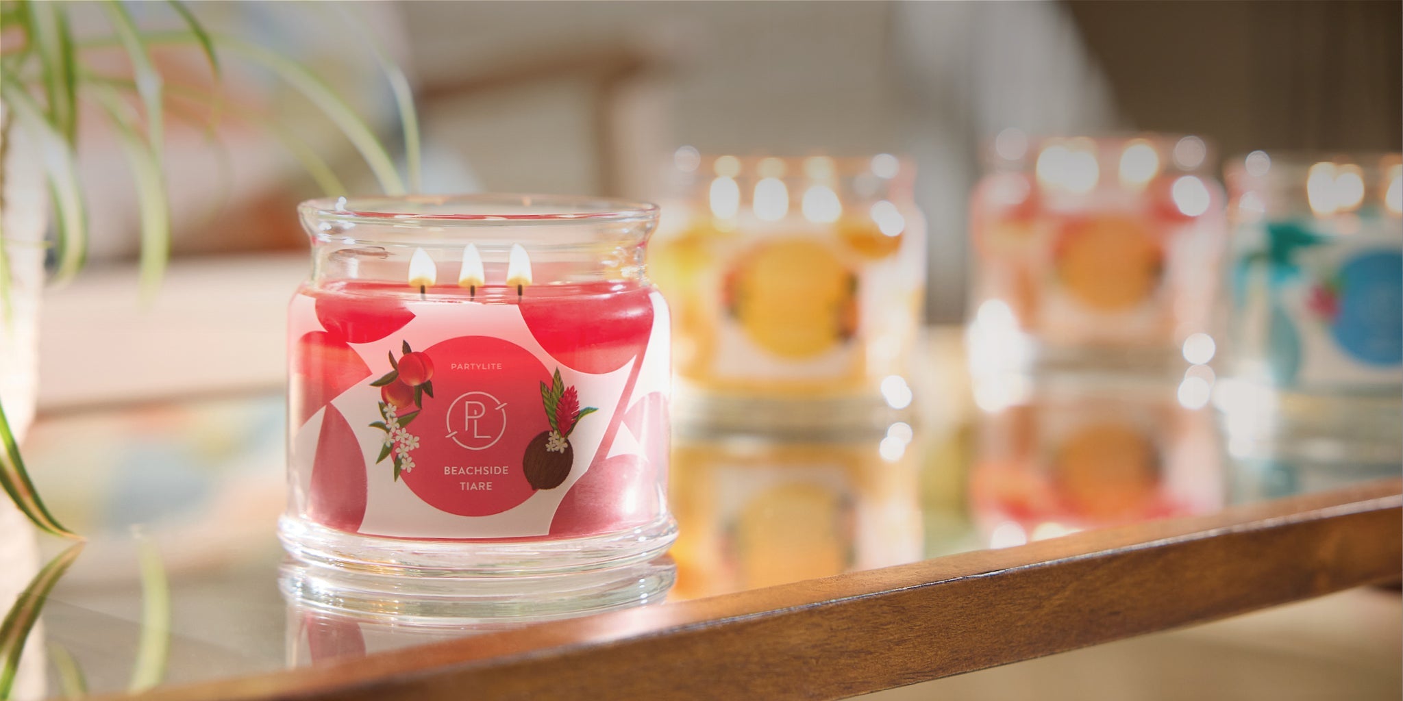 Several 3-wick jar candles on a table top. 