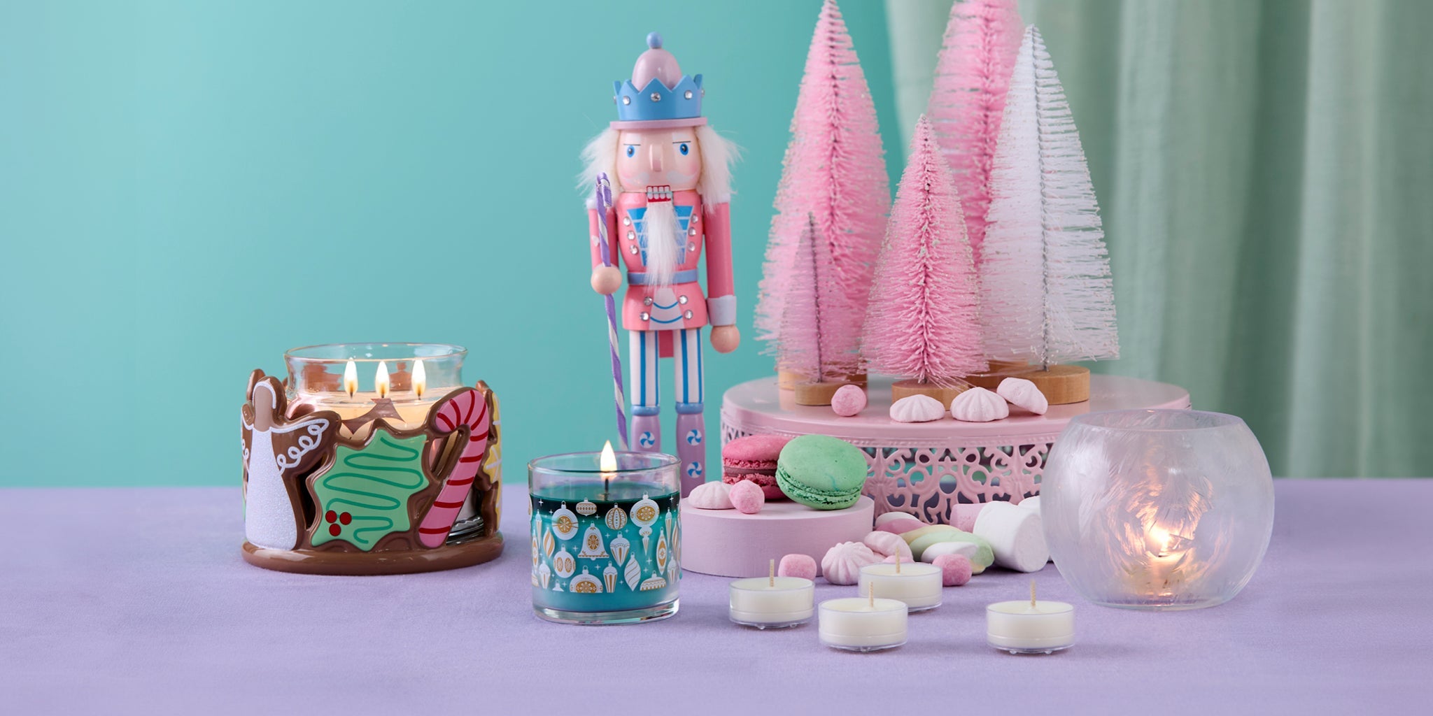 Christmas tablescape with a nutcracker, bottle brush trees and some PartyLite product including a christmas cookie jar holder, a mini jar, and a crystaline candle holder.