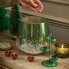 Lacy Green Hurricane shown with levelling beads, a green tealight tree and unlit tealights on a wooden surface.