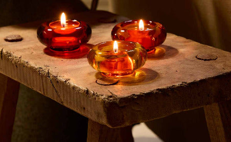 Lit Golden Honey Trio tealight holders on a wooden stool 
